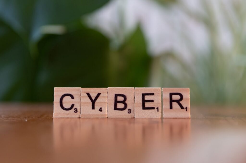 The Art of Drawing Readers In: Your attractive post title goes here Wooden letter tiles spelling 'CYBER' on a blurred background, representing cybersecurity.