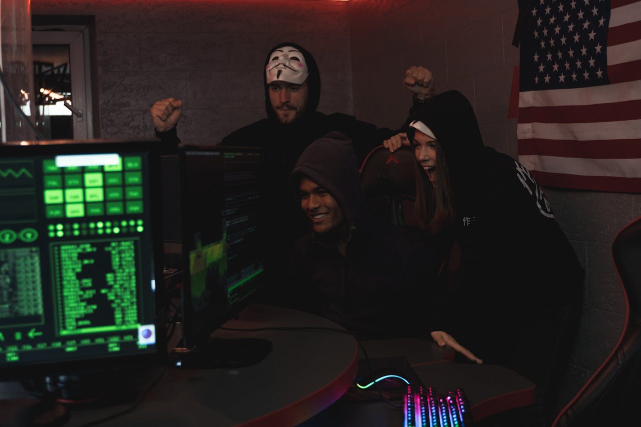 Offerings Group of tech enthusiasts in hoodies celebrate a successful cybersecurity operation indoors.